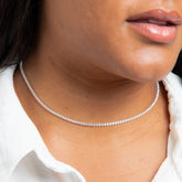 Close-up of a person wearing a delicate silver necklace.